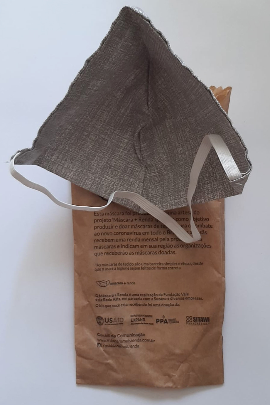 triângulos de tecido unidos por uma única fita elástica que foram entregues em sacos estampados com o selo da agência norte-americana USAid e instruções de uso que correspondem a outros modelos.
